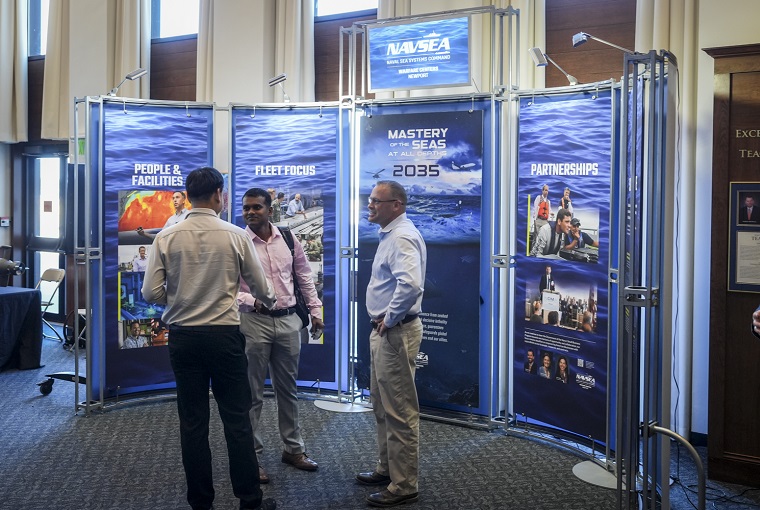Several people in front of a display